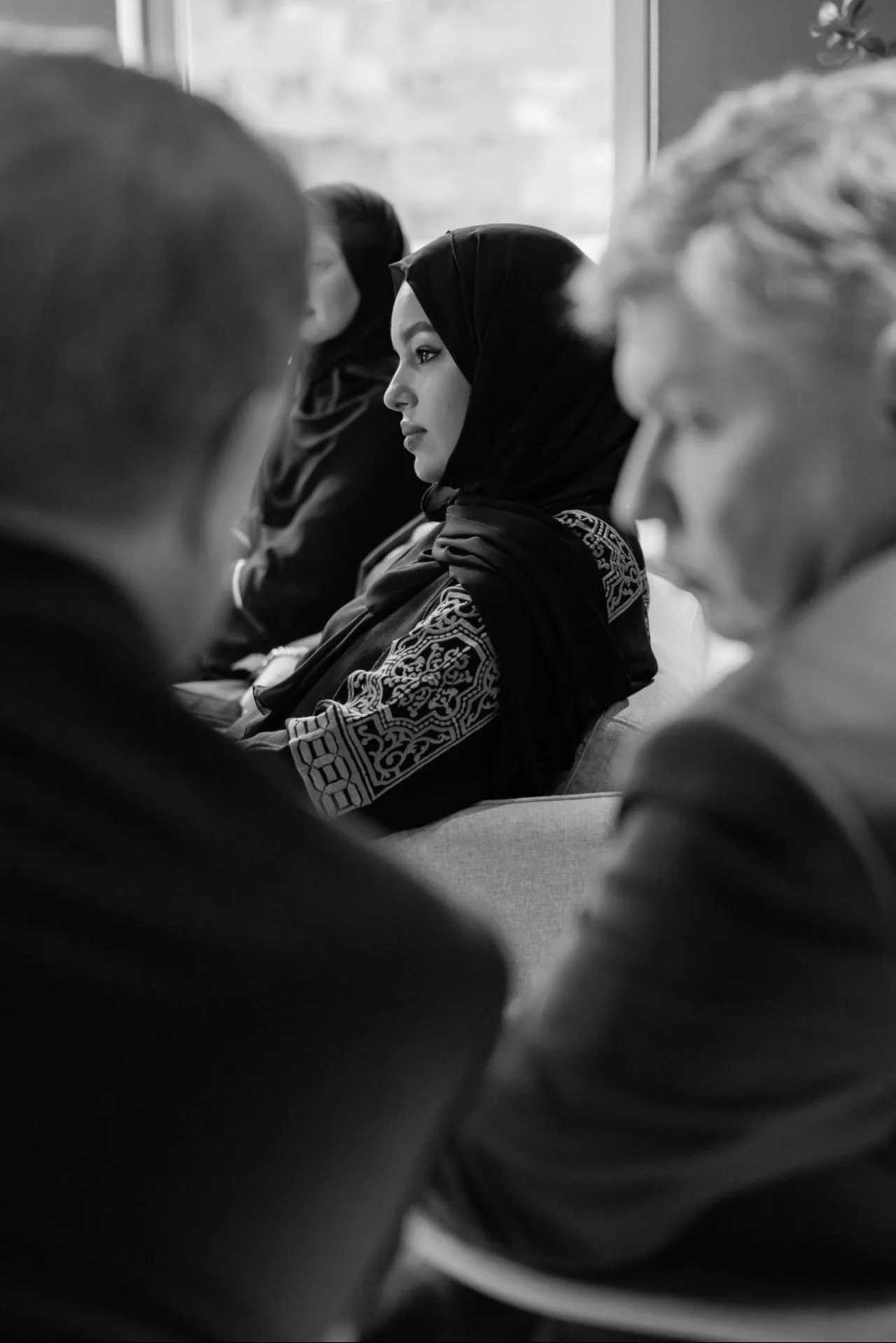 Black and white profile moment of Mesbaha Hamed during a meeting